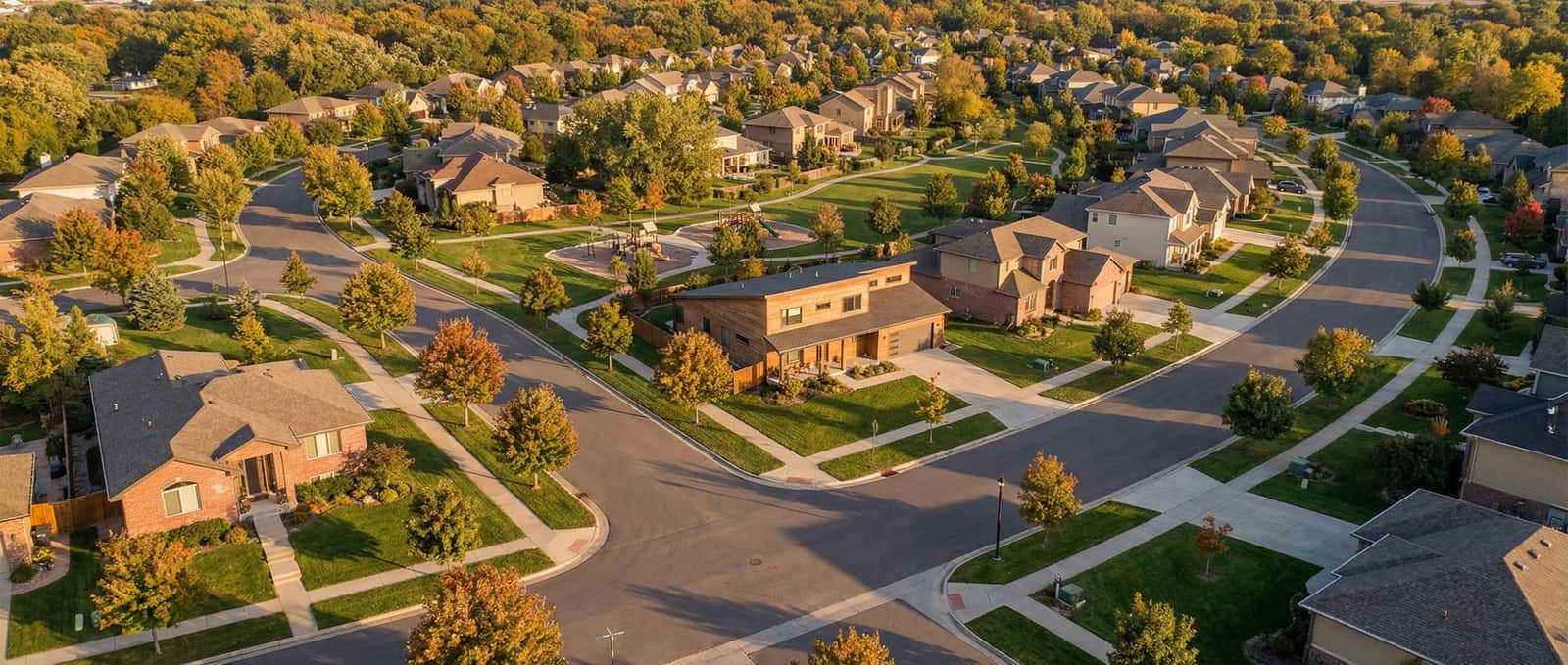 Modern suburban neighborhood with tree-lined streets at golden hour